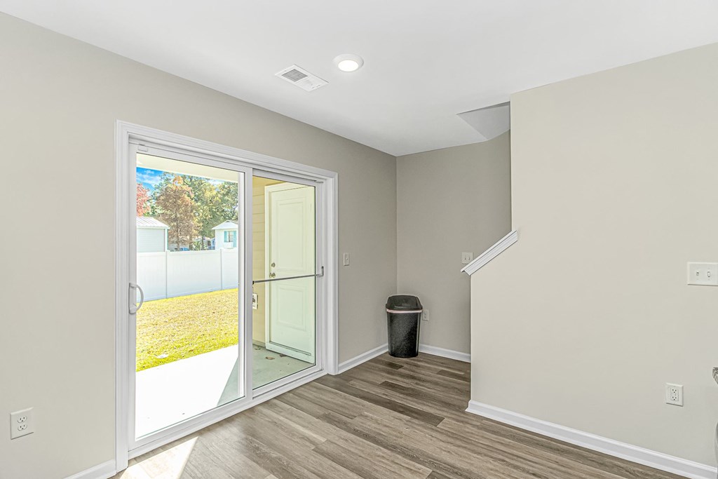 A room with a white door leading to a backyard.