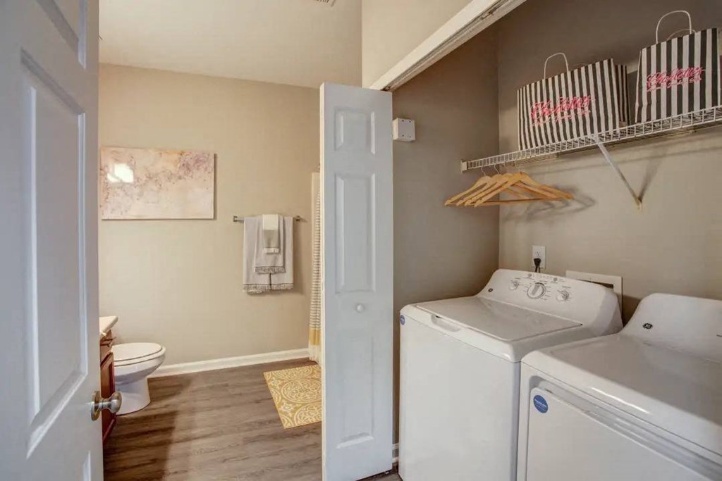 a bathroom with a washer and dryer next to a toilet