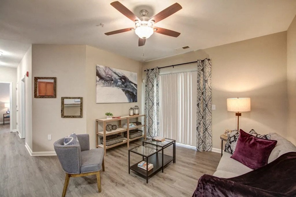 a living room with a ceiling fan and a sliding glass door