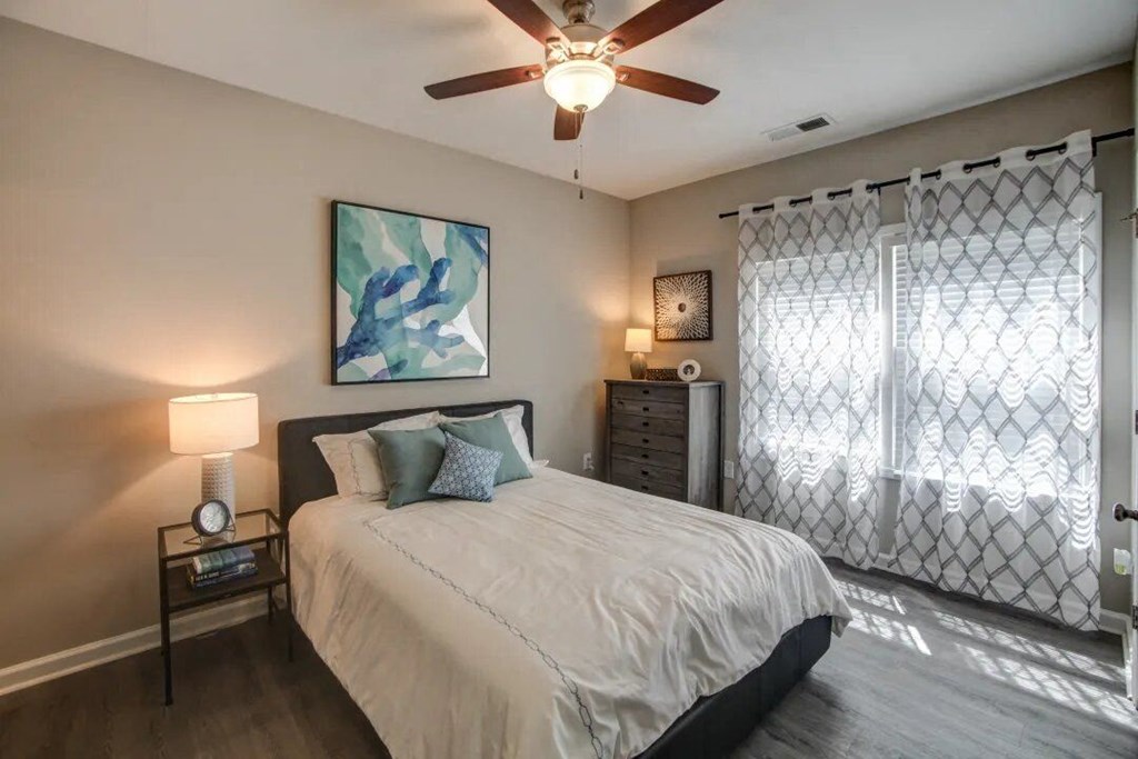 a bedroom with a bed and a ceiling fan