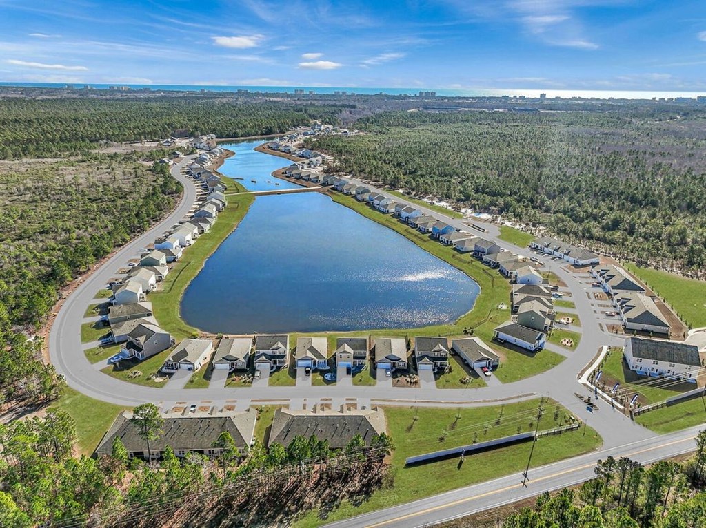 A bird's eye view of a residential area with a lake in the foreground.