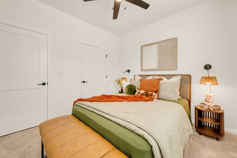 A bedroom with a bed and a ceiling fan.