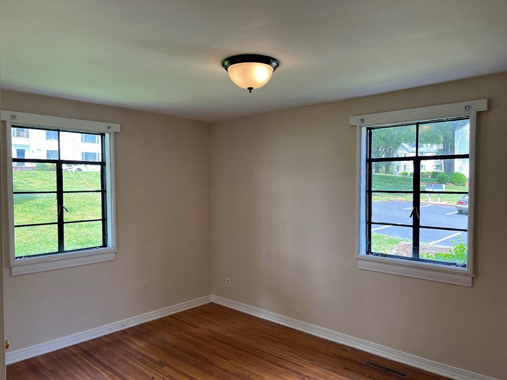 an empty room with two windows