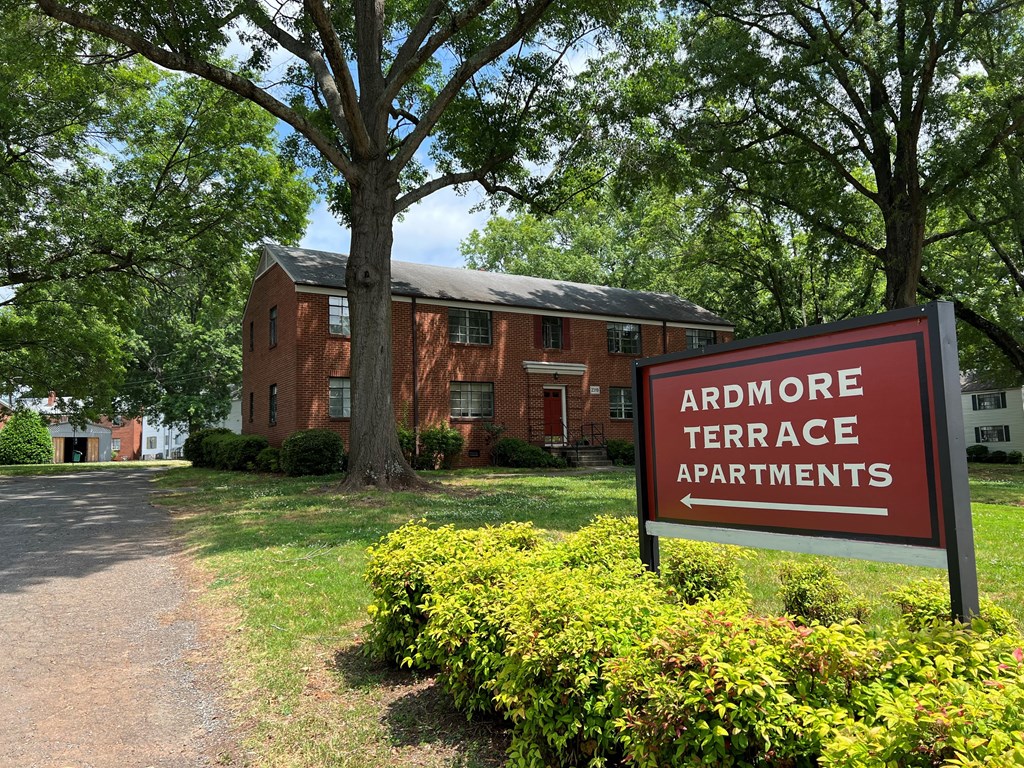 a red brick apartment building with a red sign in front of it