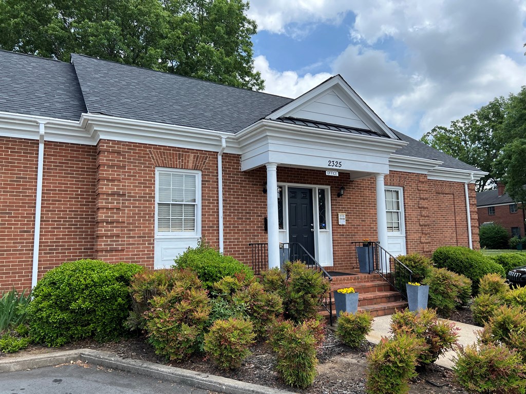 a brick building with a black door and white trim