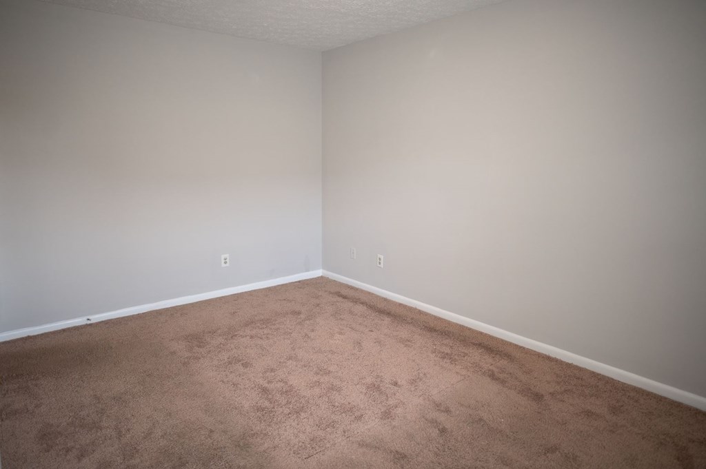 A room with a carpeted floor and white walls.
