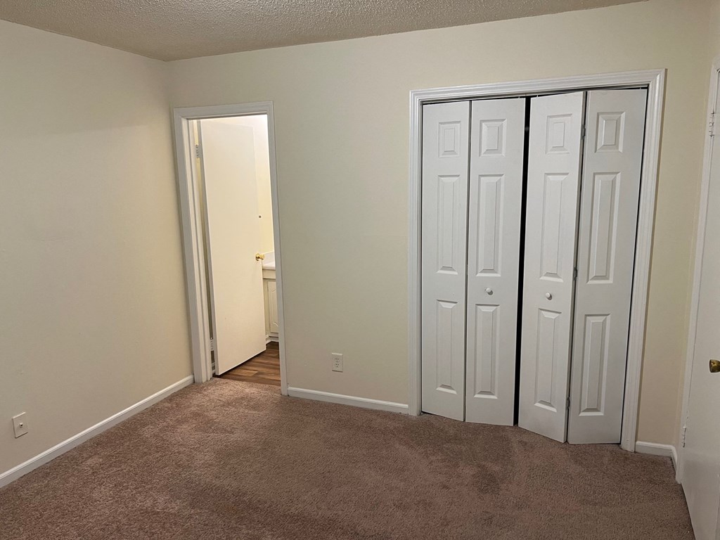 Main bedroom with closet and carpet