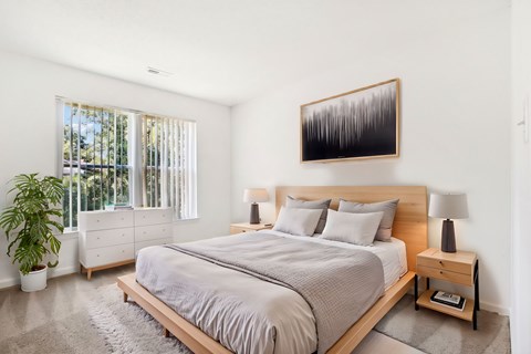 A bedroom with a large bed and a painting on the wall.