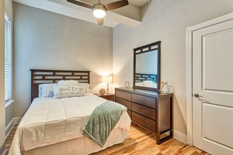 A bedroom with a bed, nightstand, and a ceiling fan.