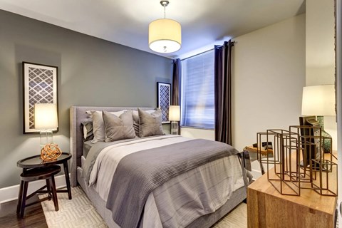 A bedroom with a large bed and a side table with a bottle on it.