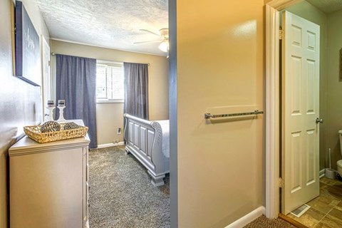 A room with a white door and a window with curtains.