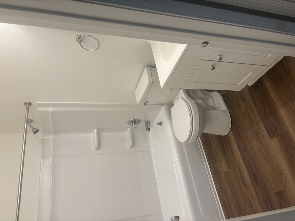 A white bathroom with a toilet and a shower.