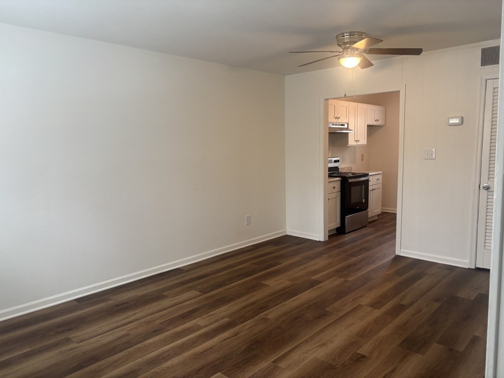 A room with wooden floors and a ceiling fan.