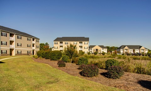 Apartment complex with green grass in front.