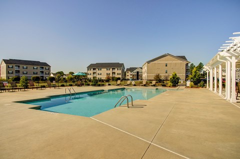 A large swimming pool in a sunny outdoor setting.