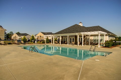 A large swimming pool in front of a house.