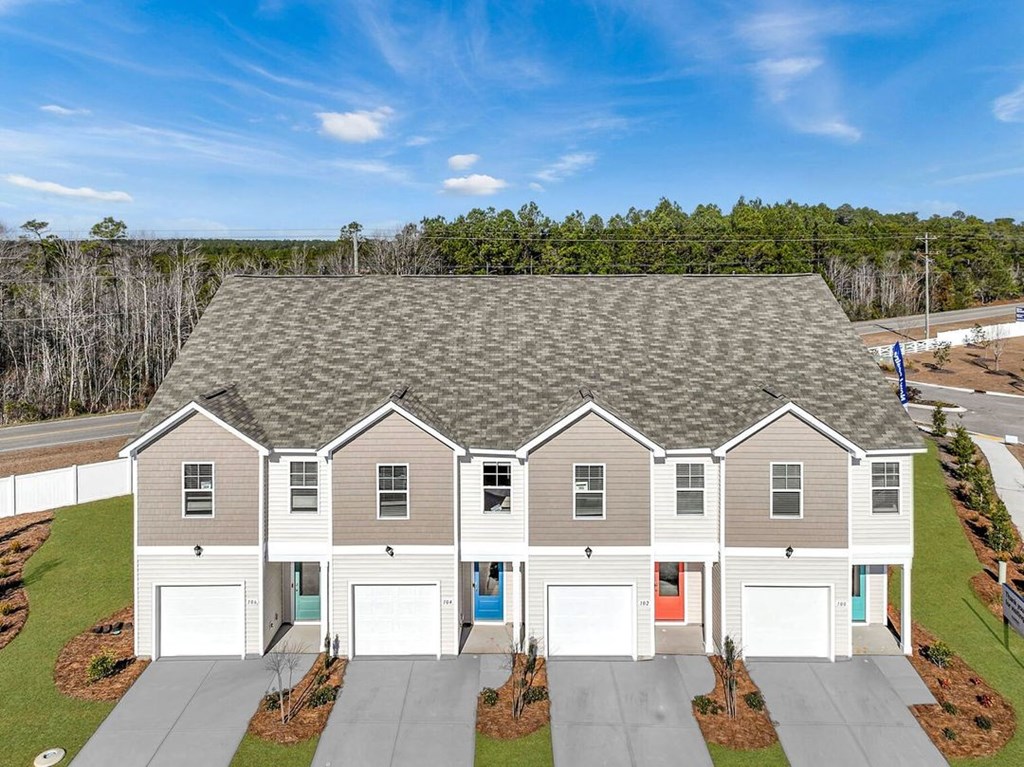 A large house with a grey roof and four garages.