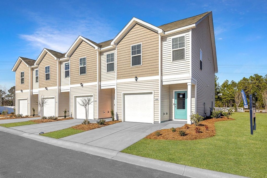 A row of houses with a clear blue sky above them.