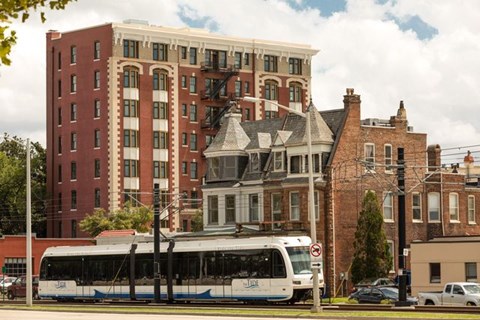 A bus is parked in front of a tall building.