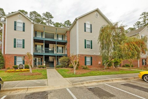 A building with a green lawn in front.