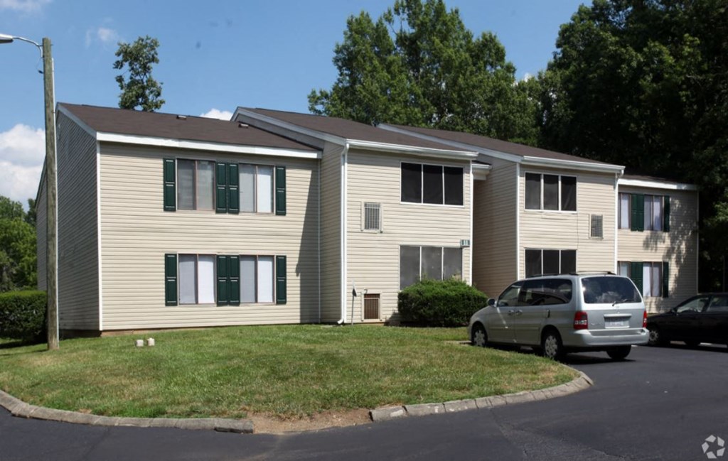 an apartment building with a car parked in front of it