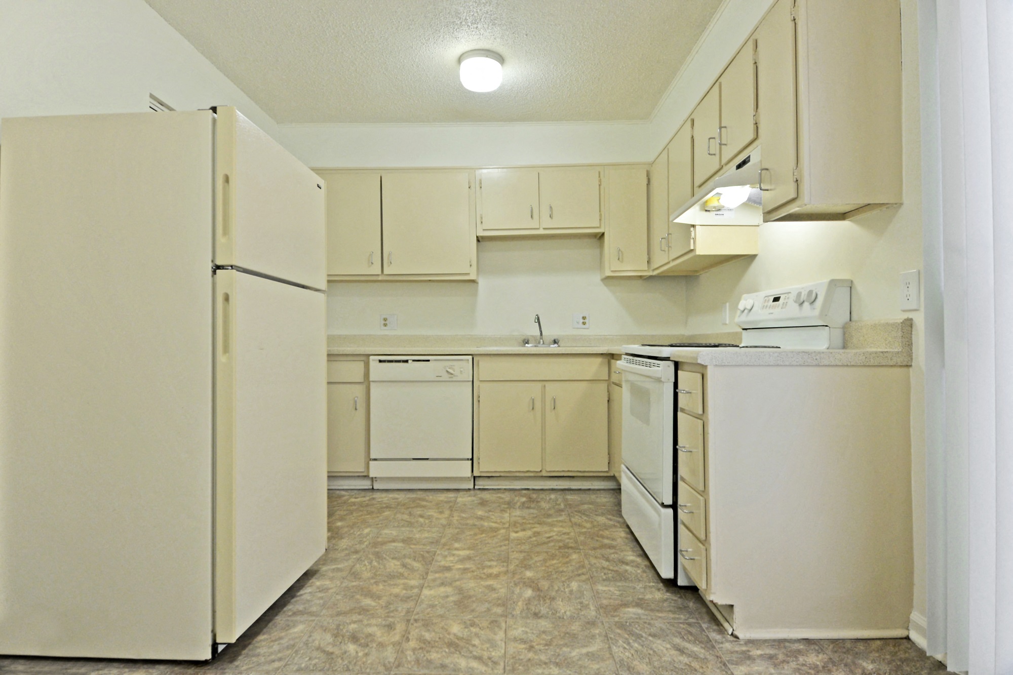 Kitchen model with white cabinets, sink, range, dishwasher, refrigerator