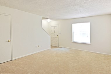 Living room in two bedroom townhome with stairs to bedrooms