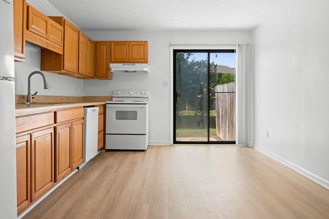 A kitchen with wooden cabinets and a white fridge.