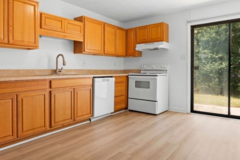 A kitchen with wooden cabinets and a white dishwasher.