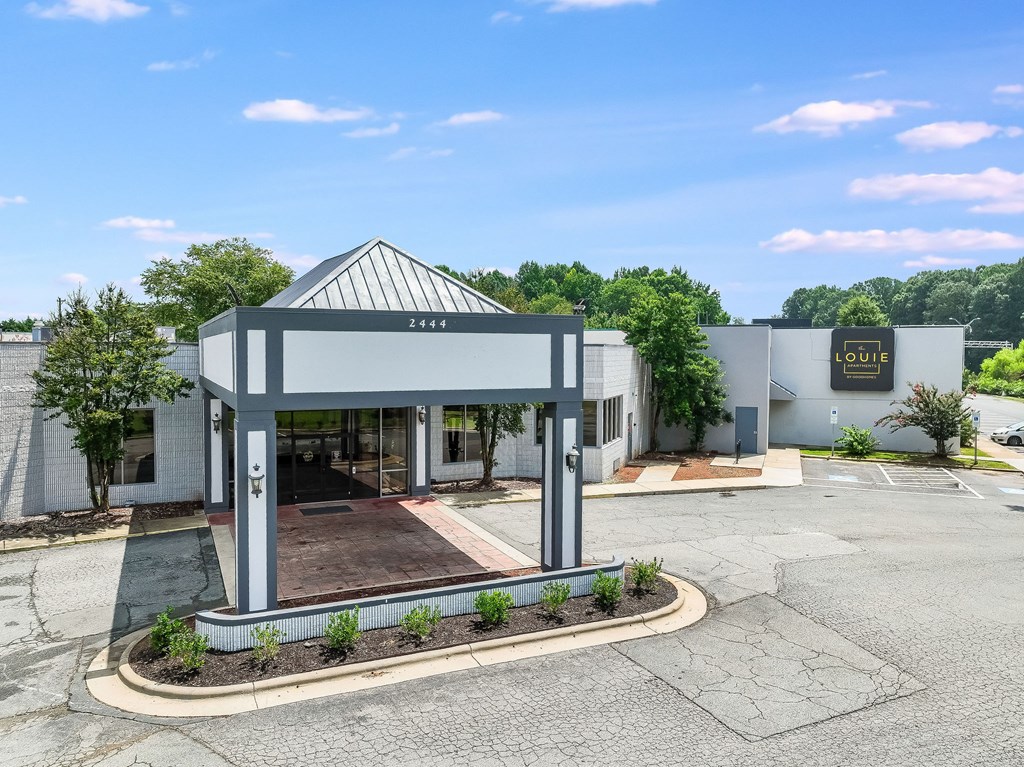 A building with the number 2414 on it is surrounded by a small garden.