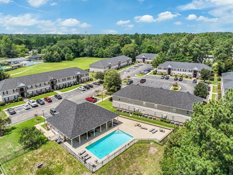 A bird's eye view of a resort with a swimming pool and multiple buildings.