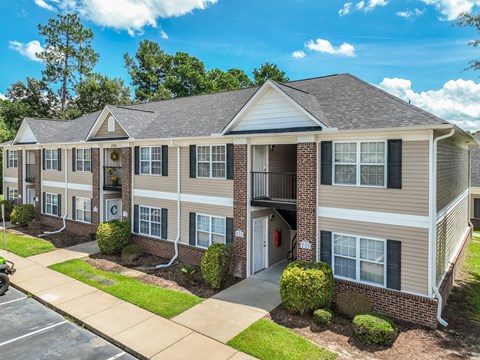 A building with a brown and beige exterior and a grey roof.