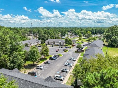 A parking lot with cars and a building in the background.