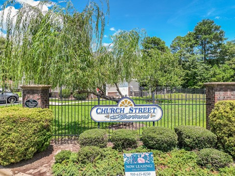 A sign that says Church Street is in front of a fence.