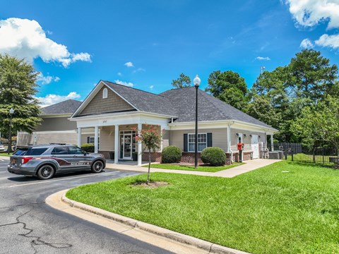 A house with a grey car parked in front.