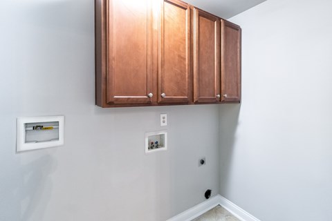 A white wall with a brown cabinet and a white switchboard.