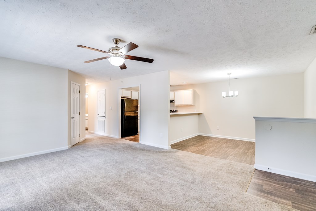 A room with a ceiling fan and carpeted floor.
