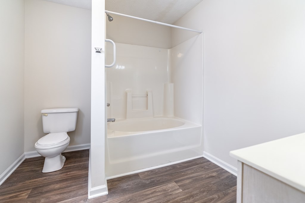 A white toilet is in a bathroom with a walk-in shower.