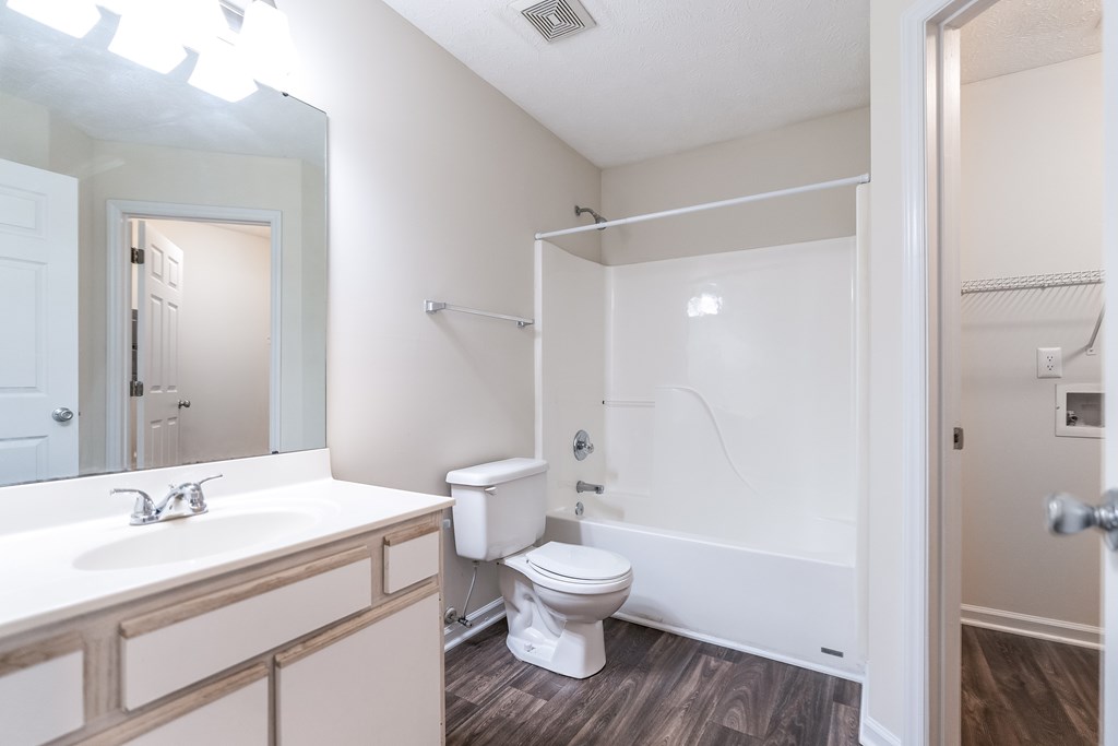A white bathroom with a toilet, sink, and bathtub.