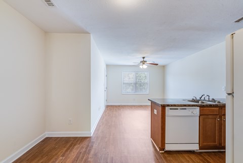 A kitchen with white appliances and wooden cabinets.