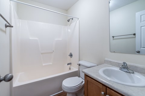 A white bathroom with a toilet, sink, and bathtub.