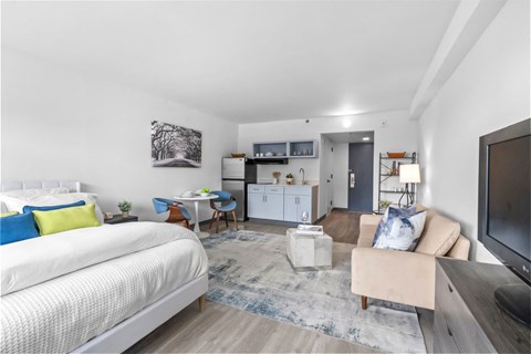 A modern bedroom with a large bed and a chair with a blue cushion.
