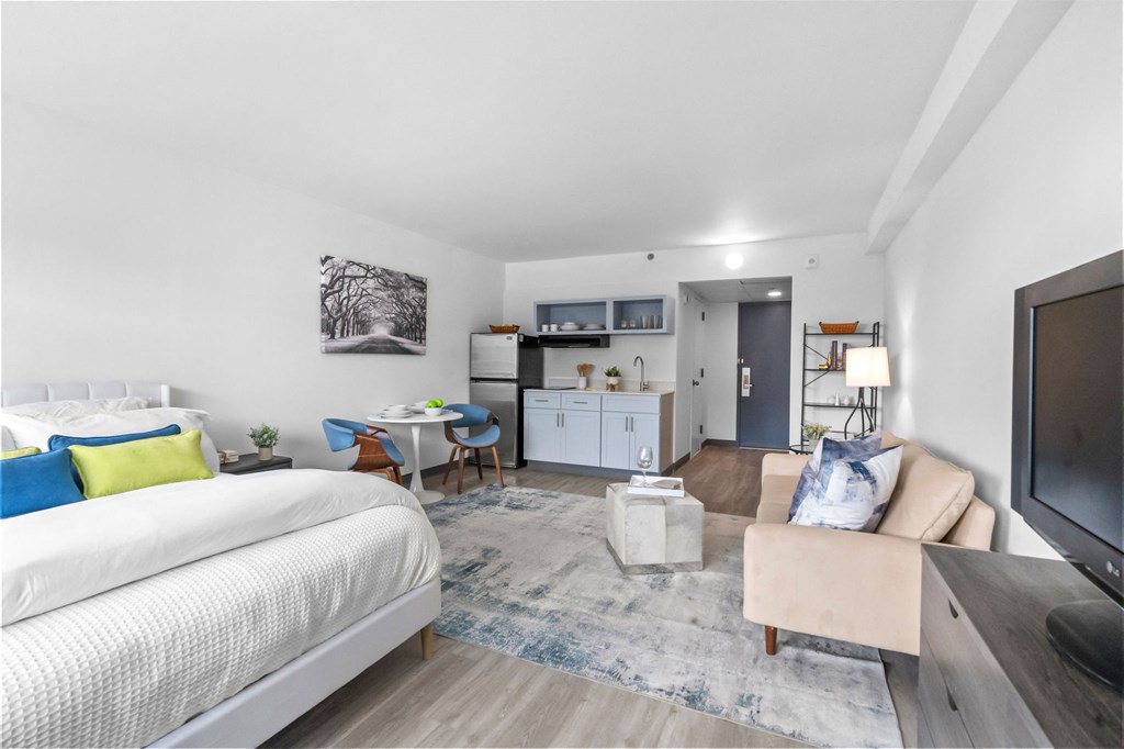 A modern bedroom with a large bed and a chair with a blue cushion.