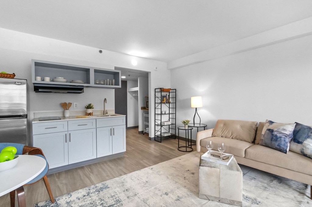 A modern kitchen with a dining table and a couch in the living room.
