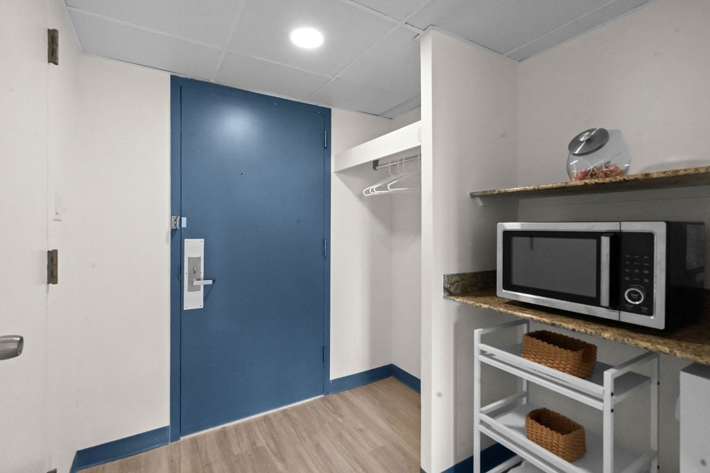 A blue door is on the left and a microwave is on the right.