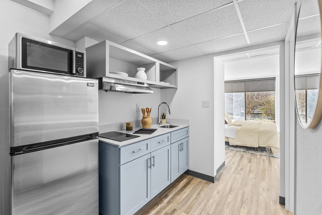 A kitchen with a stainless steel refrigerator and a white countertop.