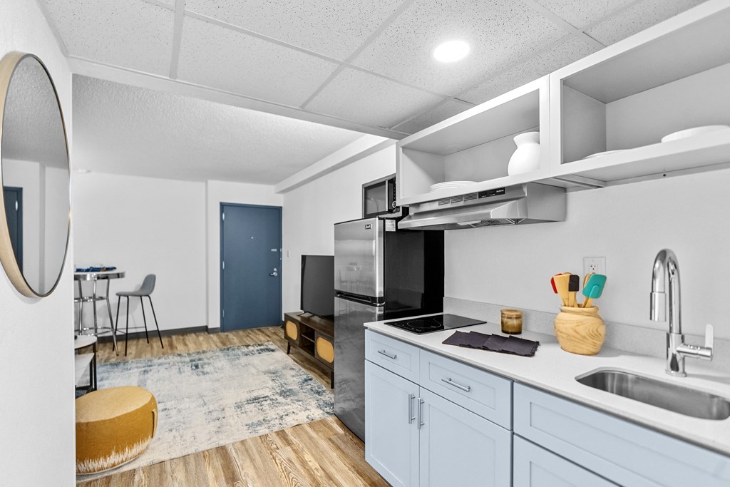 A modern kitchen with a blue cabinet and a wooden floor.