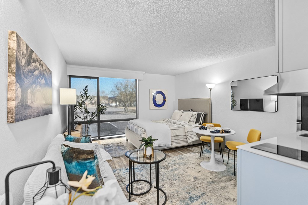 A living room with a white couch and a large window.