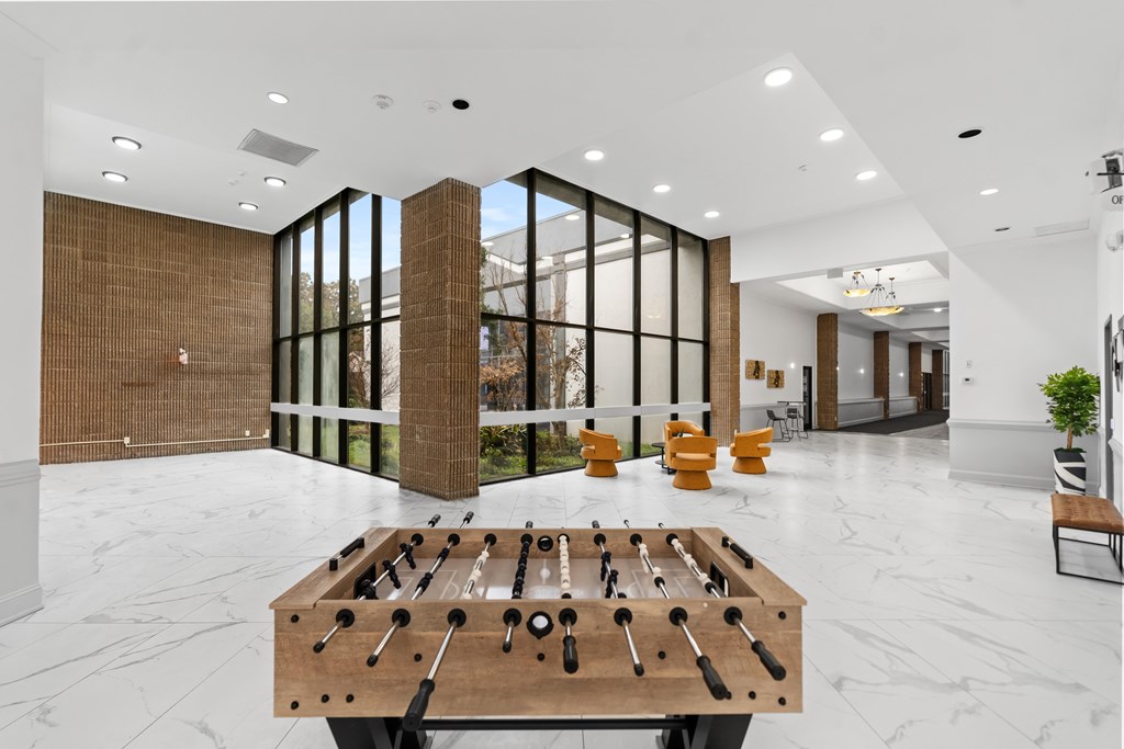 A foosball table sits in the middle of a white marble floor.
