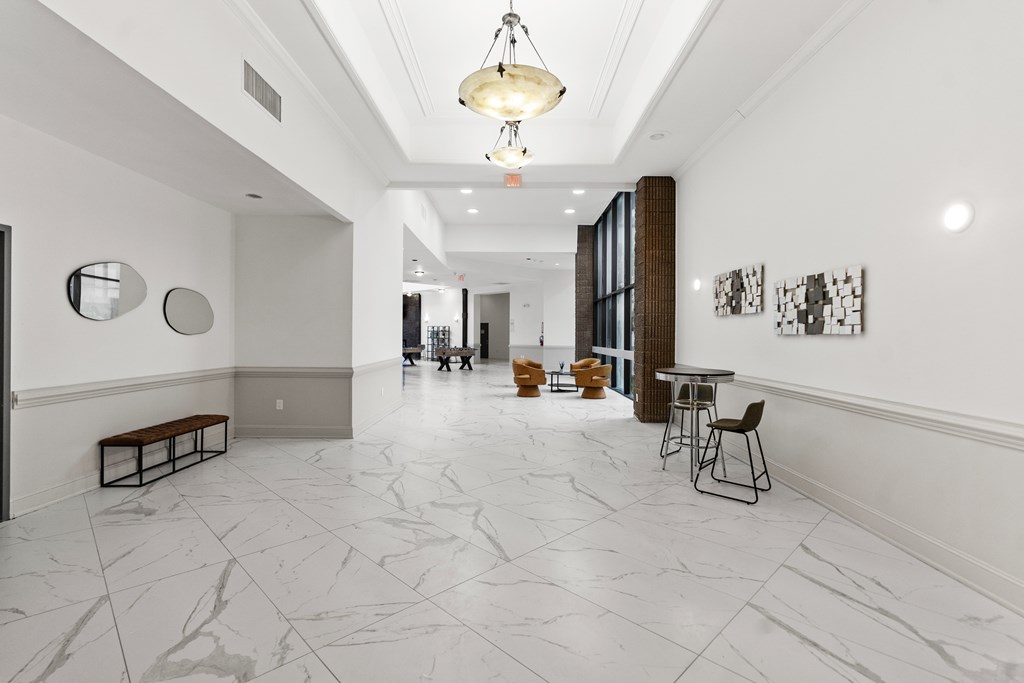 A long hallway with a marble floor and white walls.